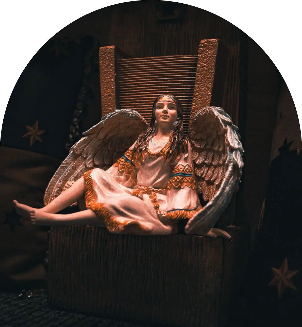 Angel figurine sitting on a wooden throne.
